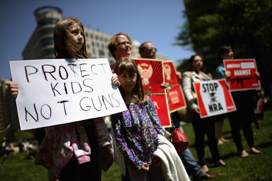 WASHINGTON, DC - APRIL 25:  Anti-gun violence demonstrators, including Rachel Ahrens (L), 13, Abby Ahrens, 8, and their mother Betty Ahrens hold signs condeming the National Rifle Association during a protest in McPhearson Square April 25, 2013 in Washington, DC. Angry with the U.S. Senate's failure to pass an expansion of background checks for people wanting to buy guns, the demonstrators attempted to deliver faux bank checks and crime scene photos to a handful of lobbying firms that represent the NRA.  (Photo by Chip Somodevilla/Getty Images)