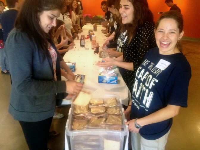 Jasreen Gupta (L) and Hannah Little (R) were among 102 UC Irvine students  spending part of their Saturday doing community service work. At The Center for Living Peace in Irvine, the two packaged sandwiches for Orange County's Second Harvest Food Bank.