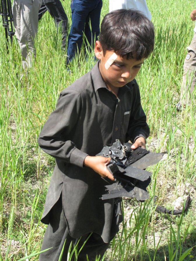 A boy collects small pieces of wreckage that were strewn in the area  following the U.S. raid that killed bin Laden.
