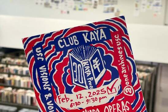 A photograph of a hand holding up a flyer for "Club Kaya," happening February 12, 2025 at 6:30 p.m. The hand-painted art uses blue, red, and white colors. 
