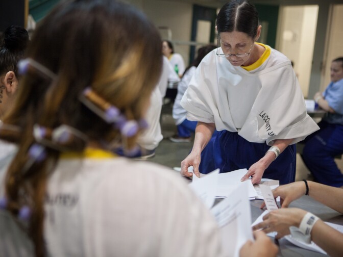 Caryn Quincey hands out an inspirational poem to women enrolled in the Education Based Incarceration class at the Twin Towers Correctional Facility on October 2nd, 2013.