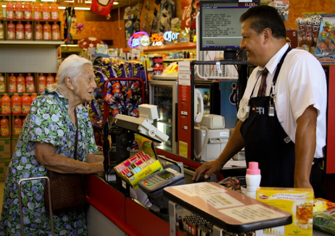 Super A night manager, Hector Reyes, chats with a customer at the check out. 