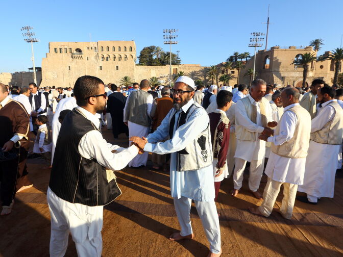 Libyan Muslim worshippers greet each other as they gather at the Martyrs' Square in the capital Tripoli to perform Eid al-Fitr prayers on June 25, 2017 to mark the end of the fasting month of Ramadan. / AFP PHOTO / MAHMUD TURKIA        (Photo credit should read MAHMUD TURKIA/AFP/Getty Images)