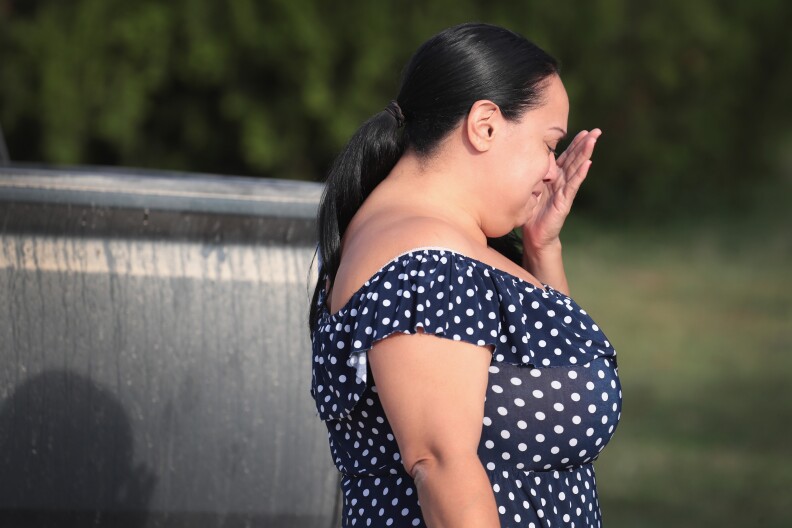 SUTHERLAND SPRINGS, TX - NOVEMBER 06:  Meredeth Cooper wipes away a tear after handing flowers to a police officer guarding a road block near the First Baptist Church of Sutherland Springs on November 6, 2017 in Sutherland Springs, Texas. On November 5 a gunman, Devin Patrick Kelly, killed 26 people at the church and wounded many more when he opened fire during a Sunday service.  (Photo by Scott Olson/Getty Images)