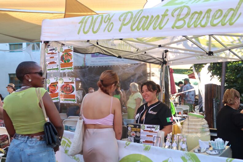 A group of people standing in front of a plant-based food stall