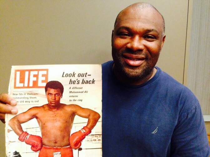 Larry G. Earl, Jr. - the founder and principal of 1619 Exhibits, holding one of the magazines that are featured in his new exhibition, "From Cassius Clay to Muhammad Ali."
