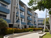 A three story apartment building is painted in blue and white.