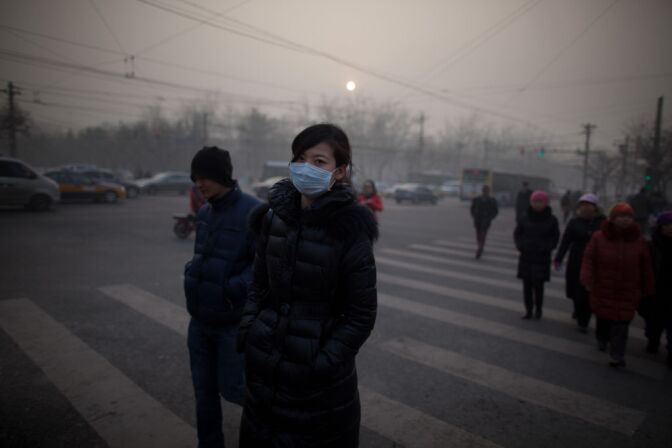 A woman wearing a mask crosses a road during severe pollution in Beijing on January 12, 2013. Air quality data released via the US embassy Twitter feed recorded air quality index levels so hazardous that they were classed as 'Beyond Index'. The US embassy website advised against all outdoor activity.