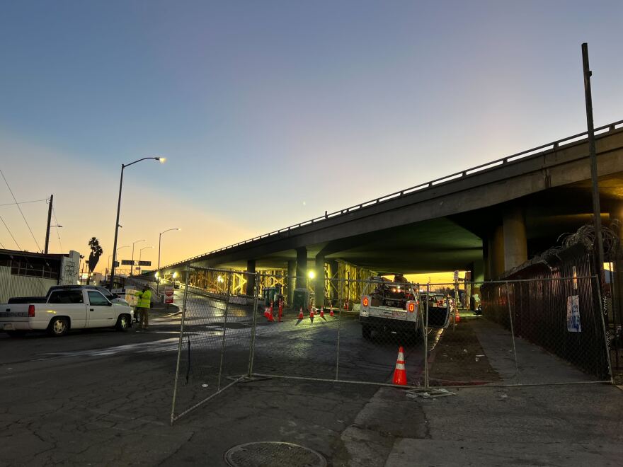 Wood scaffolding is visible under a raised roadway.
