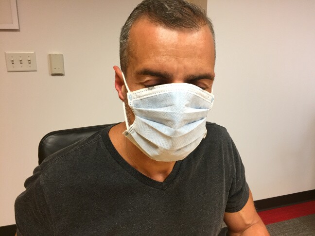 A man tries on a surgical mask.