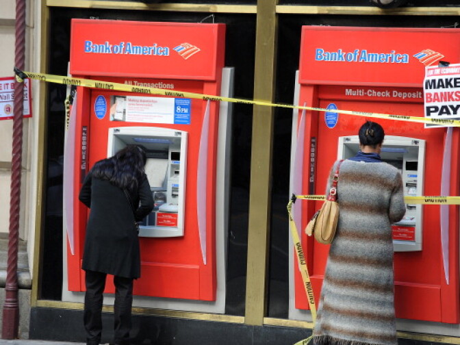 Passersby use Bank of America ATM machines after protestors cover the machines with yellow danger tape and protest signs, outside a Bank of America branch in downtown Los Angeles October 6, 2011 during an anti-Wall Street demonstration. At least 10 protestors werre arrested after they entered the bank branch and refused to leave. The arrests came at the end of a march of about 500 protestors from labor unions, Occupy LA and other groups who marched passed banks and other financial institutions. 