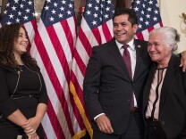 Representative-elect Jimmy Gomez, D-Calif., center, puts his arm around his mother Socorro Gomez, right, as he wife Mary Hodge look on at left, before participating in a ceremonial swearing-in on Capitol Hill in Washington, Tuesday, July 11, 2017.