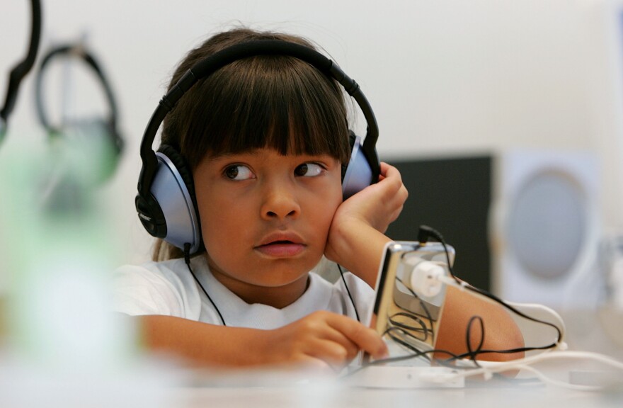 Six-year-old Emma Cordell listens to a new iPod on display at the Apple Store in San Francisco, California.
