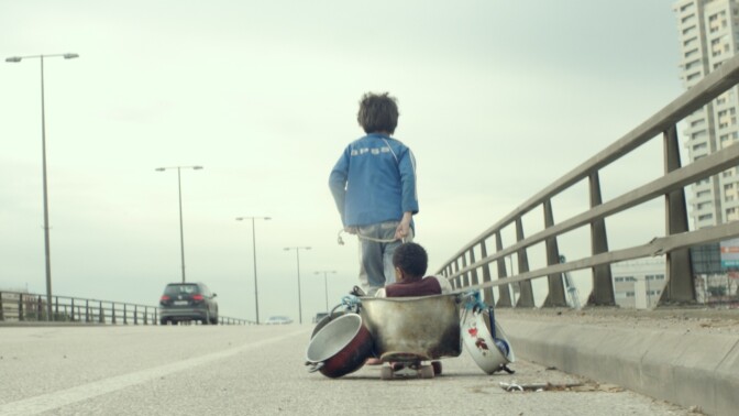 Zain (Zain Al Rafeea) pulls companion Yonas (Boluwatife Treasure Bankole) on a makeshift wagon in the movie <em>Capernaum.</em>