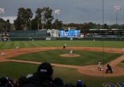 A game is underway at a baseball stadium with lights. The scoreboard reads: Jackie Robinson Stadium UCLA Bruins.