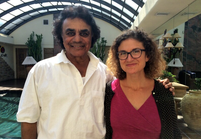 Johnny Mathis and Alex Cohen standing in his living room.