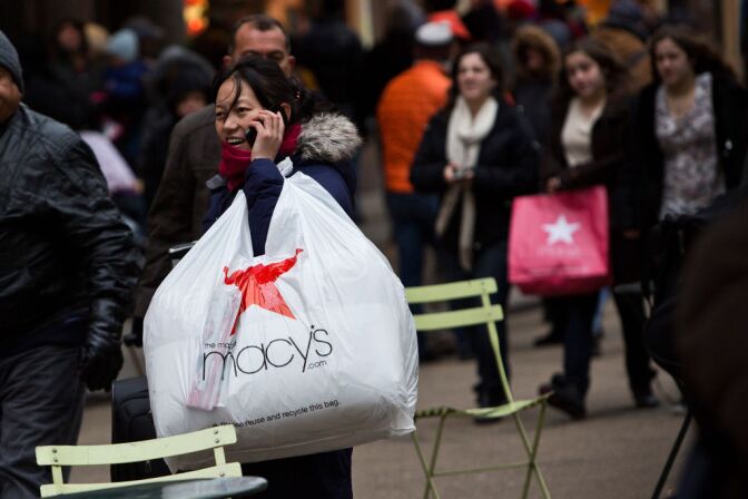The Commerce Department Friday said Americans cut back on spending in April after their income failed to grow, a sign economic growth may be slowing. The department said the decline in consumer spending is the first since May 2012. (A shopper talks on the phone after leaving Macy's department store in in New York City. Photo by Andrew Burton/Getty Images)