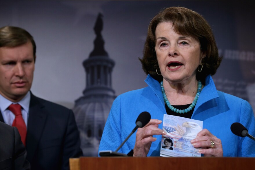 Senate Select Committee on Intelligence ranking member Sen. Dianne Feinstein holds up her passport during a news conference about Democratic legislative proposals in the wake of last week's terror attacks in Paris.