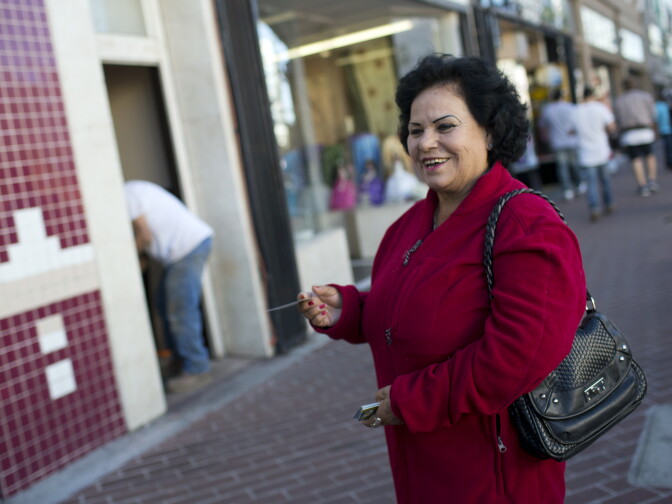 Alicia Gonzalez hands out business cards advertising Cazuelas Panchito, a restaurant in downtown Santa Ana, along Calle Cuatro on Wednesday, Jan. 14. Handing out flyers for local businesses is common on Calle Cuatro. 
