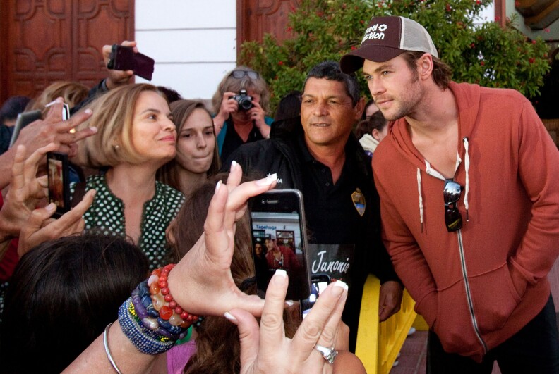 Australian actor Chris Hemsworth (R) poses with fans in Playa de Santiago, on the Spanish Canary island of La Gomera on November 23, 2013, during the shooting of the film 'In the Heart of the Sea' by US director Ron Howard. With its outrigger canoes and sailing whaler anchored off the coast, a Hollywood blockbuster started shooting more than three months ago in the small port of Playa de Santiago, where the few bars and restaurants are now always full thanks to the production. A godsend, welcomed in this region of Spain battered by the crisis and an unemployment rate reaching 35.1%. 