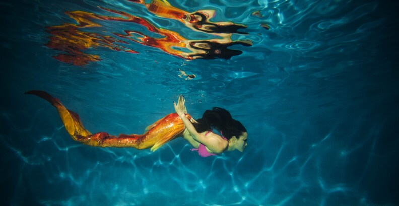 This photo taken on July 26, 2015 shows a woman clad in her self-made mermaid costume swimming in a pool in China's southwest Chongqing municipality.
