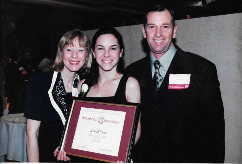 Lisa Frost poses with an award from Boston University with her parents Tom and Melanie