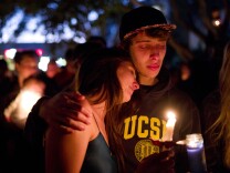 Two students comfort each other during a candlelight vigil held to honor the victims of Friday night's mass shooting on Saturday, May 24, 2014, in Isla Vista, Calif. Sheriff's officials said Elliot Rodger, 22, went on a rampage near the University of California, Santa Barbara, stabbing three people to death at his apartment before shooting and killing three more in a crime spree through a nearby neighborhood. (AP Photo/Jae C. Hong)