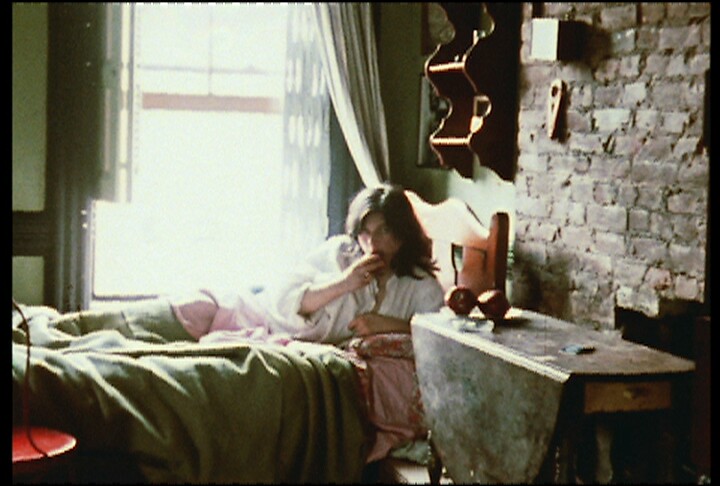 film still of a woman on a bed