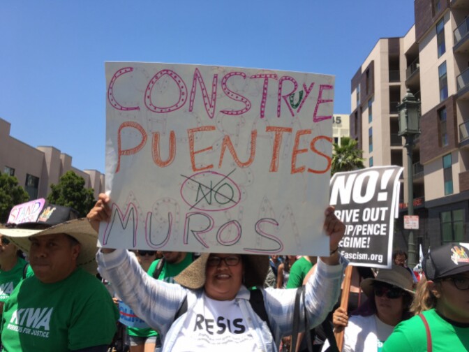 Silvia Rivera of Koreatown holds up a sign that reads "Build Bridges Not Walls" during the May Day rally in Los Angeles. 