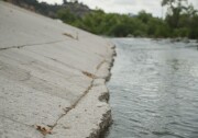 The Los Angeles River flows through the Frogtown neighborhood in Los Angeles, California. The river's banks are mostly concrete. 