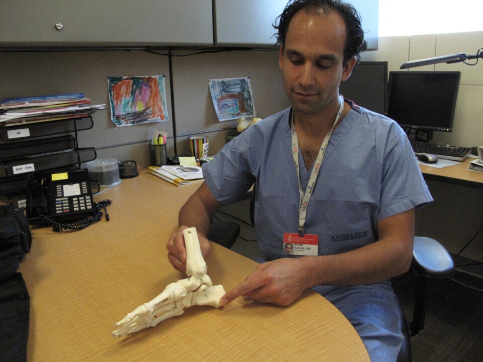Dr. Naven Duggal, an  orthopedic surgeon at Beth  Israel Deaconess Hospital in Boston, shows on a model of the foot where the  plantar fascia runs, from the heel to the base of the toes.