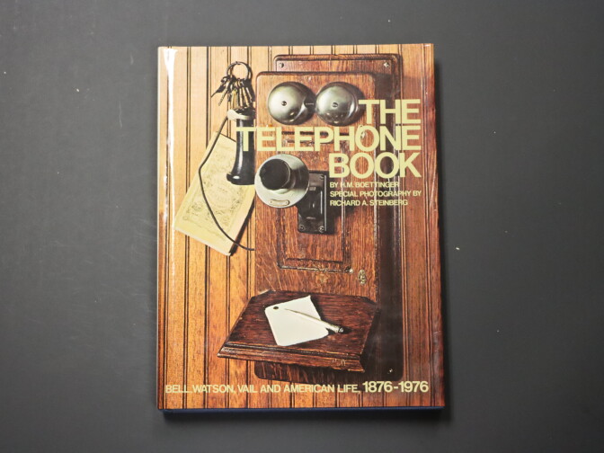 A brown telephone book with the image of a vintage phone on the front. The book reads "The Telephone Book ... Bell, Watson, Vail and American Life, 1876-1976"