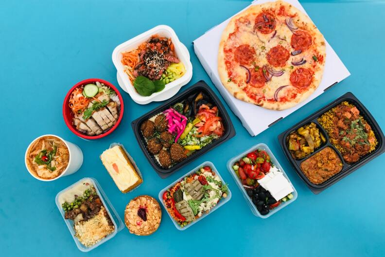 an assortment of food including pizza, a bagel, falafel, salad and soup is set against a blue background