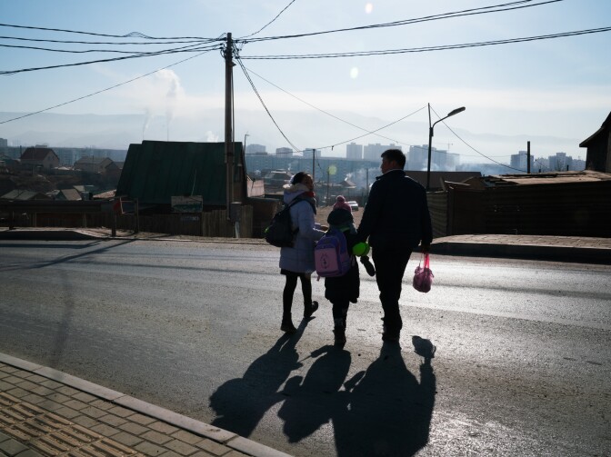 Oyutan lives with his family in Ulaanbaatar's <em>ger</em> district, an unplanned area on the capital city's outskirts where low-income migrants have settled. He escorts two of his daughters to school, wary of distracted drivers.