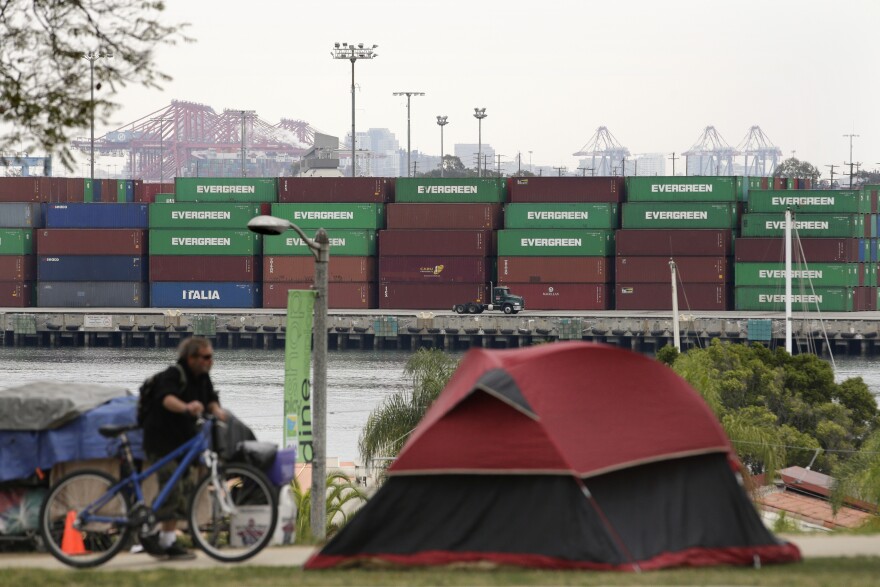 A tent pitched by a homeless person sits on the hilltop overlooking the Port of Los Angeles, Tuesday, Feb. 17, 2015, in Los Angeles. Seaports in the U.S. West Coast that were all but shut over the weekend because of a contract dispute are reopening as the nation's top labor official tries to solve a stalemate between dockworkers and their employers that already has disrupted billions of dollars in U.S. international trade. (AP Photo/Jae C. Hong)