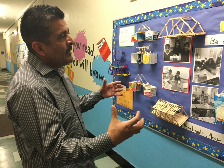 Richard Ramos, principal of Haddon STEAM Academy, shows off students' model bridge-building projects on display in the hallways of the school in Pacoima. He hopes to create a magnet program at Haddon.