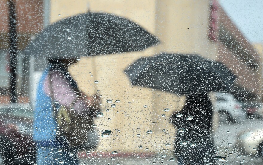 File: Women use umbrellas under a steady rainfall on Sept. 15, 2015 in Los Angeles.