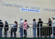 File: People wait in line outside of the State of California Department of Motor Vehicles (DMV) in Los Angeles, California on February 13, 2009.