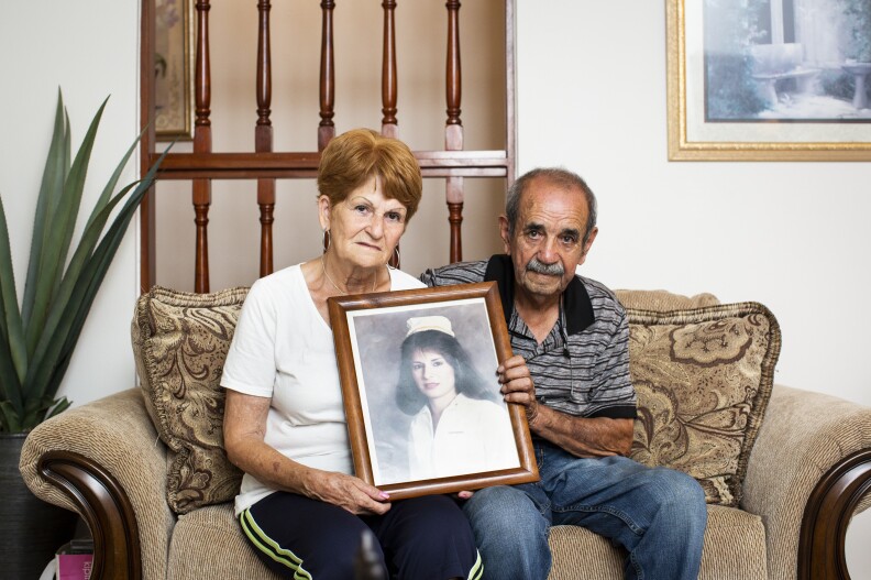 Nereida Maldonado, 74, and Sotero Viera, 80, hold a portrait of their daughter Madeline, who died 25 years ago. She was buried at the Lares Municipal Cemetery until January, when her parents had her remains exhumed and reburied 16 miles away.