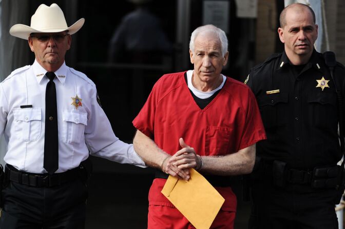 Former Penn State assistant football coach Jerry Sandusky (C) leaves the Centre County Courthouse after being sentenced in his child sex abuse case on October 9, 2012 in Bellefonte, Pennsylvania. The 68-year-old Sandusky was sentenced to at least 30 years and not more that 60 years in prison for his conviction in June on 45 counts of child sexual abuse, including while he was the defensive coordinator for the Penn State college football team.