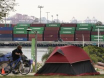 A tent pitched by a homeless person sits on the hilltop overlooking the Port of Los Angeles, Tuesday, Feb. 17, 2015, in Los Angeles. Seaports in the U.S. West Coast that were all but shut over the weekend because of a contract dispute are reopening as the nation's top labor official tries to solve a stalemate between dockworkers and their employers that already has disrupted billions of dollars in U.S. international trade. (AP Photo/Jae C. Hong)