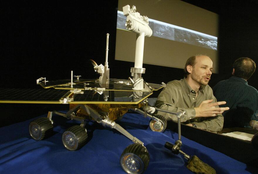 PASADENA, UNITED STATES:  Activity Lead Dr. Rick Welch discusses the lastest images (BACKGROUND) returned from the martian surface by the Mars Exploration Rover (MER) Opportunity 28 January 2004 at a press conference at NASA's Jet Propulsion Laboratory (JPL) in Pasadena, California.  JPL's second rover, Opportunity is returning images from its landing site at Meridiani Planum. AFP PHOTO / Robyn BECK  (Photo credit should read ROBYN BECK/AFP/Getty Images)