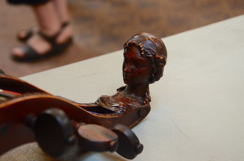 A traditional carved head on an original, early 18th-century bass viol.