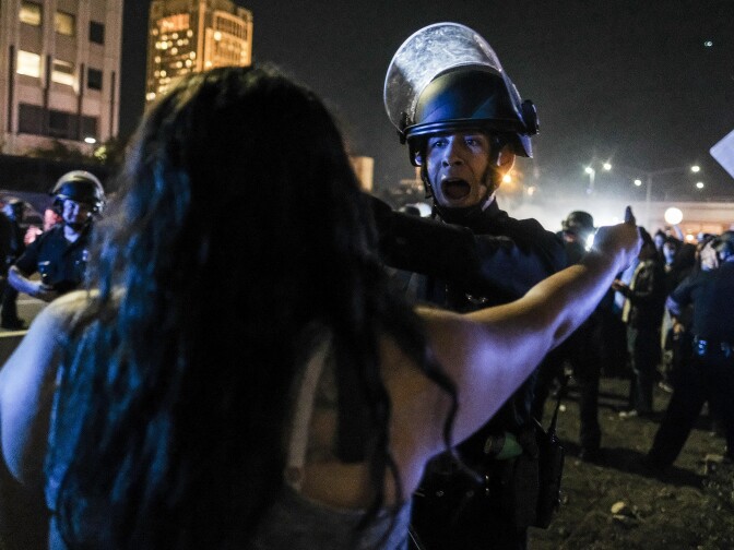 A protester (foreground) confronts police as demonstrators shut down the 101 Freeway, a major thoroughfare in the city, following a rally to protest a day after President-elect Donald Trump's election victory in Los Angeles, California, late on November 9, 2016.
Protesters burned a giant orange-haired head of Donald Trump in effigy, lit fires ins the streets and blocked traffic lanes late on November 9 as rage over the billionaire's election victory spilled onto the streets of US cities. From New York to Los Angeles, thousands of people in around 10 cities rallied against the president-elect a day after his stunning win, some carrying signs declaiming "Not our President" and "Love trumps hate." / AFP / RINGO CHIU        (Photo credit should read RINGO CHIU/AFP/Getty Images)