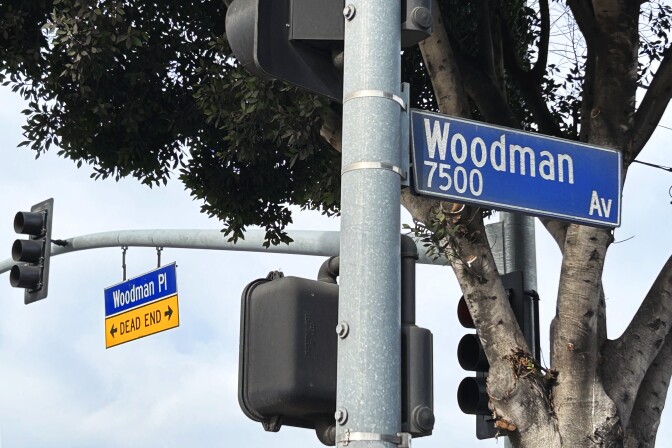 Street signs on the corner of Woodman Place and Woodman Avenue.