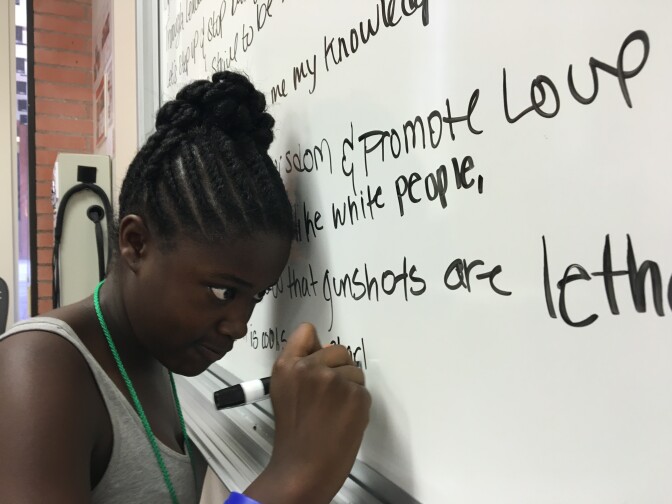 Aaliyah Smith, 13, writes a line of poetry on a whiteboard in a small classroom on the University of Southern California campus. Smith is part of a group of seventh- and eighth graders that's group-writing a poem about race and social justice issues that they'll share on the last day of a seven-week summer program called "Freedom School," modeled after the civil rights-era alternative schools set up to teach African-Americans how to organize and protest. More than 120 black and Latino kids of all ages attended the program.