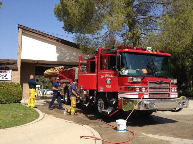 Fire fighters from Glendale's 23rd company clean the truck the morning after putting out a rapid brush fire that threatened many homes. 
