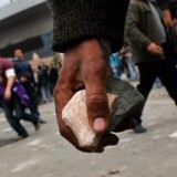 Anti-government protesters carry rocks to throw at pro-government supporters near a highway overpass on the edge of Tahrir Square the afternoon of February 3, 2011 in Cairo, Egypt.