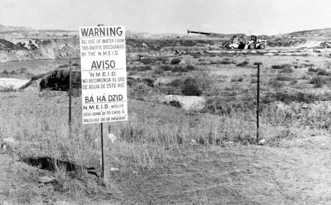 FILE - This Nov. 13, 1975, file photo, shows signs along the Rio Puerco warning residents in three languages to avoid the water in Church Rock, N.M. after a uranium tailings spill. A group representing Navajo communities is presenting its case to an international human rights body, saying U.S. regulators violated the rights of tribal members when they cleared the way for uranium mining in western New Mexico. (AP Photo/SMH,File)