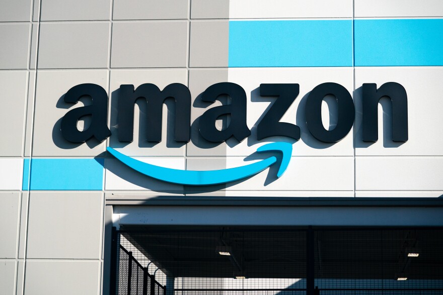 The exterior of a building is seen with a large Amazon logo.